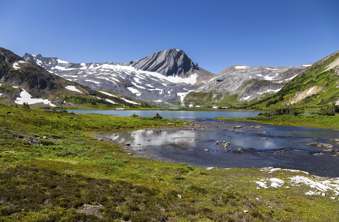 Classic view of Aster Lake near the outlet by backcountry campsite. Warrior Mtn in the background