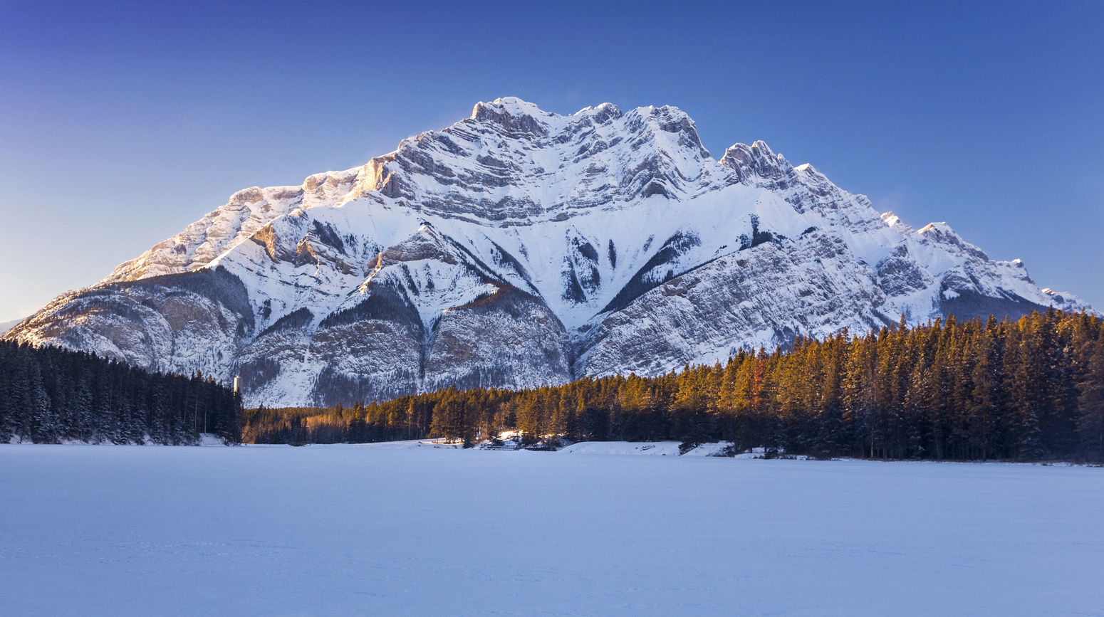 Cascade Mountain Towering on west side of snow covered Johnson Lake in winter